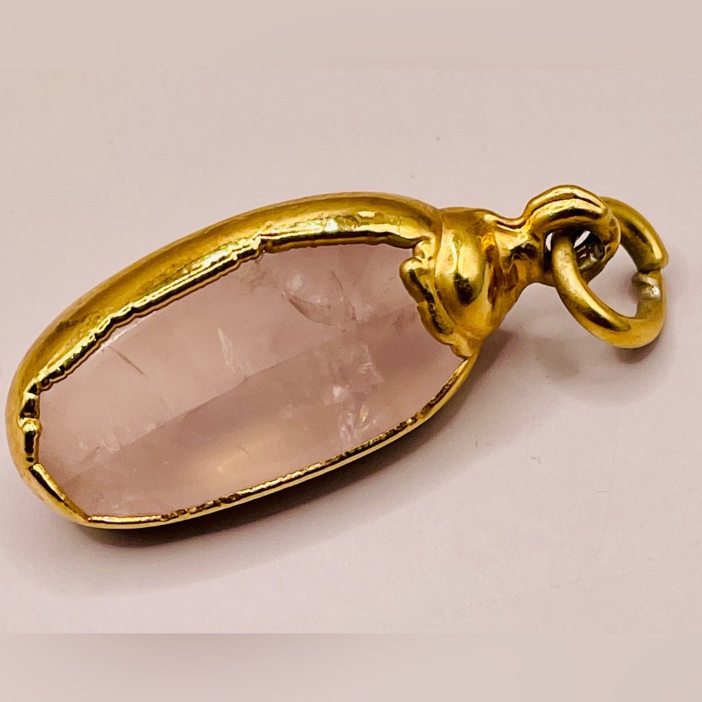 Rose quartz with a gold tone frame pendant. Smooth and has unique shape. Boho